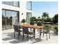 Ensemble de salle à manger d'extérieur avec table en bois et chaises en osier sur une terrasse moderne.
