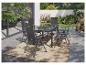 Ensemble de mobilier de jardin avec table et chaises grises sur une terrasse avec tapis.