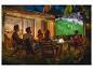 Amis regardant un match de football en plein air sur grand écran la nuit.
