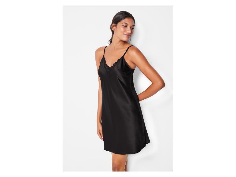 Une femme portant une robe de nuit noire en satin avec de la dentelle.