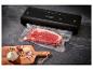 Machine sous vide Silvercrest avec un morceau de viande, de l'ail et des grains de poivre sur une planche.