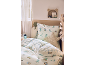 Lit d'enfant avec parure de lit dinosaure et coussin décoratif en forme d'étoile.