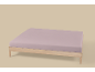 Matelas simple avec drap-housse lilas sur un cadre de lit en bois clair.