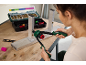 Femme utilisant une pince à riveter manuelle pour fixer des écrous à riveter sur un profilé en aluminium.