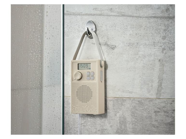Radio de douche étanche suspendue à un mur de carrelage gris.