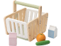 Panier de courses en bois avec lait, jus, orange et concombre.