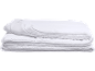 Couette blanche pliée avec bords passepoilés