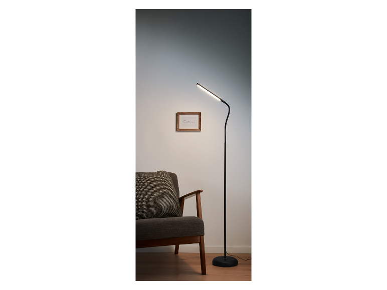 Lampe sur pied LED moderne à côté d'un fauteuil.