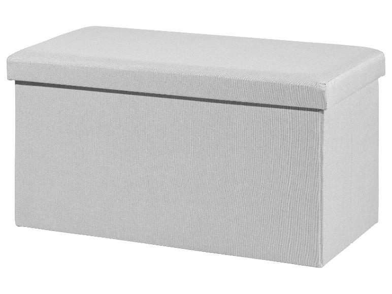 Un pouf de rangement en tissu gris clair avec un dessus rembourré.