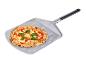 Pizza fraîchement cuite avec du basilic sur une pelle à pizza en métal.
