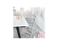 Chaise haute grise pour bébé à côté d'une table blanche avec bol et tasses.
