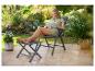 Femme se détendant sur une chaise de jardin avec repose-pieds, lisant un livre