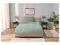 Parure de lit vert d'eau sur lit beige.