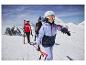 Trois skieurs en équipement d'hiver, incluant casques et lunettes, sur une montagne enneigée.
