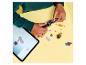 Enfant construisant un véhicule jouet avec des instructions numériques, entouré de figurines et de pièces.