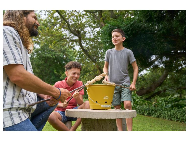 Famille cuisinant des saucisses sur un Grill Meister en plein air.