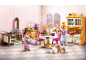 Cuisine royale miniature avec poupées, meubles et pâtisseries de jeu.