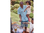 Un homme fait griller du maïs sur un barbecue avec ses deux enfants.