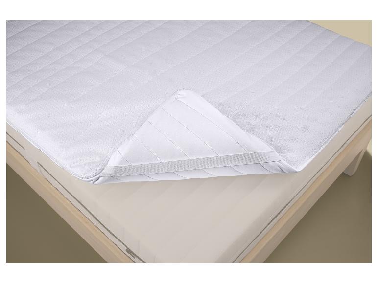 Protège-matelas blanc avec fermeture éclair partiellement ouverte sur un matelas