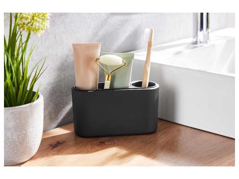 Organiseur de salle de bain noir avec brosse à dents, crème pour le visage et rouleau de jade.