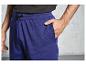 Un homme porte un pantalon de jogging bleu avec des cordons noirs.