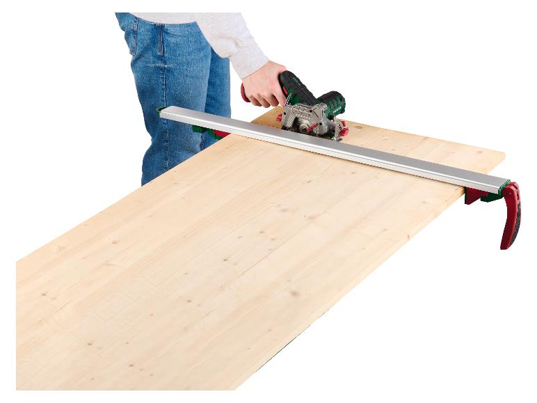 Personne utilisant une scie circulaire Parkside avec rail de guidage pour couper une planche de bois.