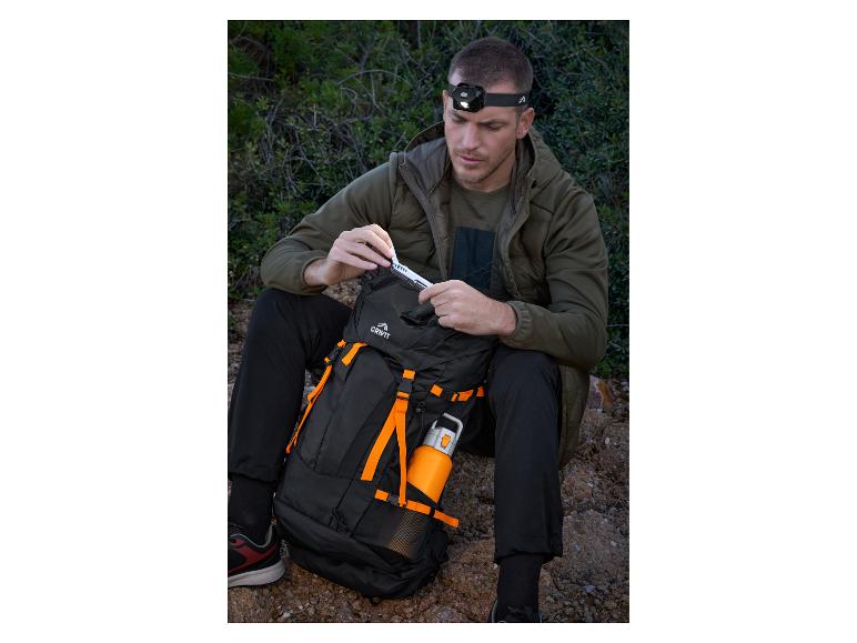 Homme avec lampe frontale et sac à dos Crivit, sortant un outil multifonction.