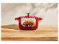 Un poulet rôti dans une cocotte en fonte rouge.