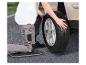 Personne changeant un pneu de voiture avec un coussin de genoux.