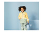 Un enfant portant un imperméable jaune et un arrosoir bleu.