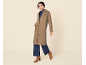 Femme en manteau marron, jean et bottes marron.