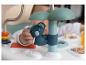 Un bébé joue avec un jouet koala bleu sur une table d'activités.