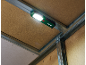 Lampe de travail fixée à une structure métallique et un panneau de bois dans un coin