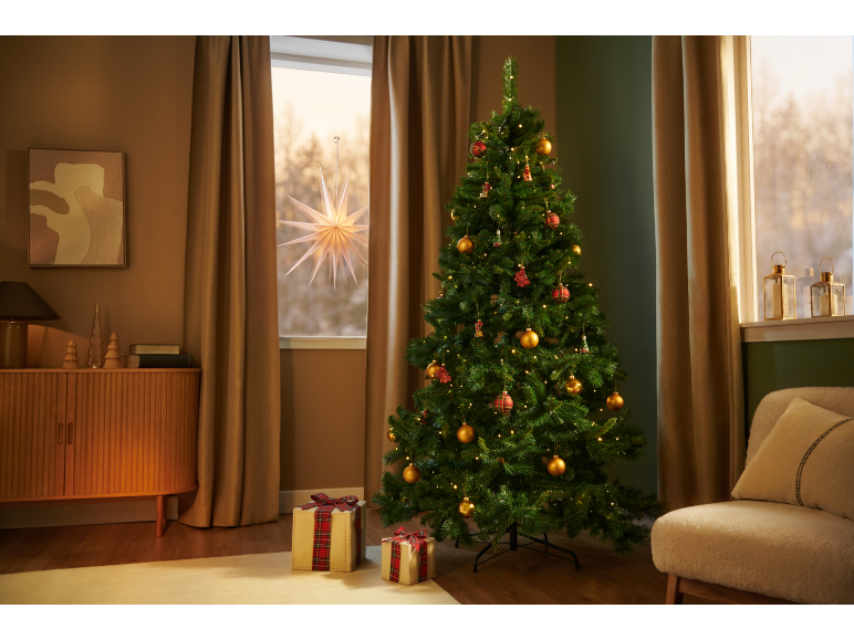 Sapin de Noël avec lumières et décorations, cadeaux, une étoile lumineuse à la fenêtre.
