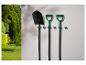 Pelles de jardin Parkside accrochées au mur, avec un jardin en arrière-plan.