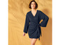 Une femme portant une robe portefeuille bleu foncé.