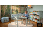Chambre d'enfant avec lit cabane, petite table et chaises, et rangement pour livres.
