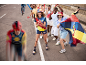 Cycliste passant devant des supporters joyeux en vêtements et accessoires de sport colorés.
