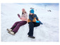 Deux enfants en vêtements d'hiver jouent dans la neige.