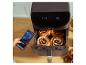 Une friteuse à air Cecotec avec des gâteaux à l'intérieur, contrôlée par un smartphone.