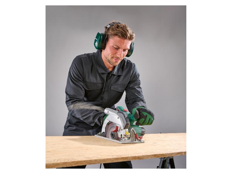 Homme en combinaison et casque anti-bruit coupant du bois avec une scie circulaire Parkside.