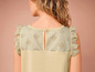 Un haut beige avec de délicats détails en broderie anglaise.
