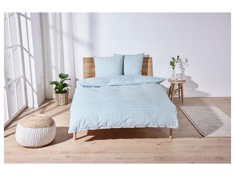 Un lit avec une couette bleu clair à carreaux.