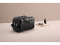 Trousse de toilette noire avec une petite bouteille et un pinceau sur une serviette.