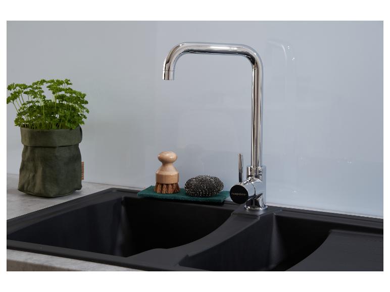 Évier de cuisine avec robinet, accessoires de lavage et persil.