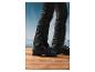 Des chaussures de ski noires sur un fond en bois