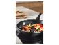 Poêle avec légumes sur plaque à induction dans une cuisine moderne.