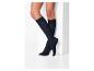 Jambes de femme en chaussettes noires montantes sur fond blanc.