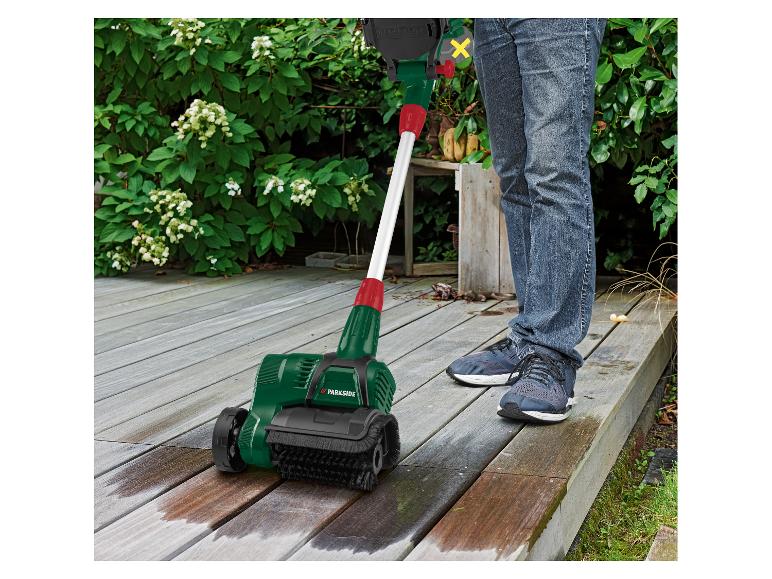 Personne nettoyant une terrasse en bois avec une brosse de nettoyage de surface Parkside.