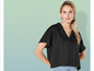 Une femme porte une chemise noire oversize à boutons.